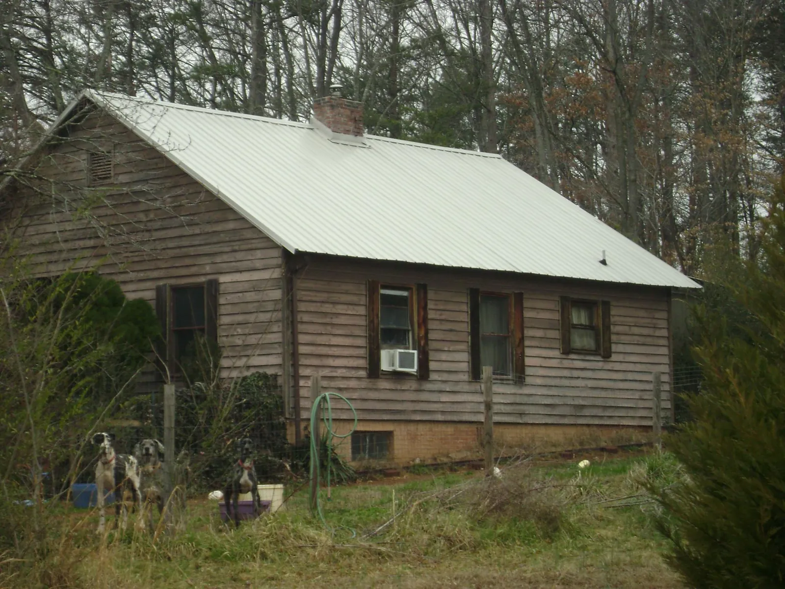 White metal roof on an old wood sided farmhouse, from a Metal Roof Installation job in Fredericksburg